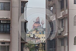 hindu god lord shiva isolated statue through building gaps at morning from different angle