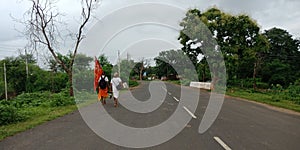 Hindu religious people going towards road for trip holded flag on hand