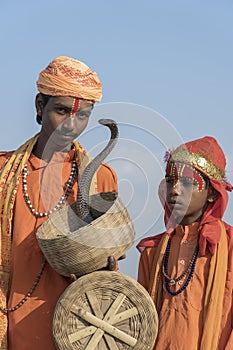Hindu sadhu holy men and snake cobra in desert Thar on time Pushkar Camel Mela near holy city Pushkar, Rajasthan, India