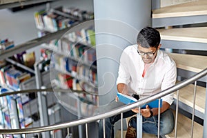 Hindu student boy or man reading book at library