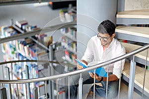 Hindu student boy or man reading book at library