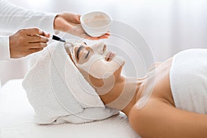 Hindu woman receiving nourishing mask at wellness spa