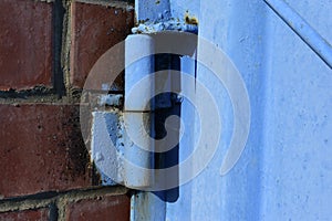 Hinged iron hinges on garage doors in blue photo