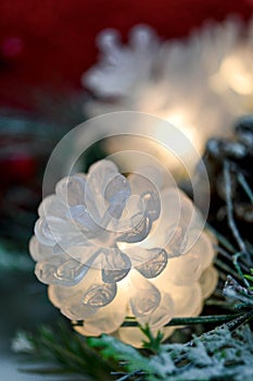 Hining white light cone garland and christmas tree branch on red bokeh background