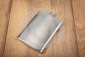 Hip flask on wooden background