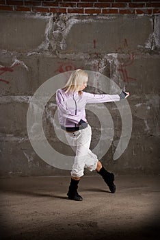 Hip hop girl dancing over grey brick wal