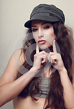 Hip-hop girl in hat posing and showing kissing