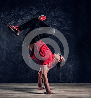 Hip-hop style dancer performs breakdance acrobatic elements.