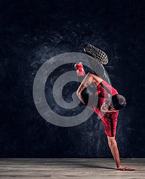 Hip-hop style dancer performs breakdance acrobatic elements.