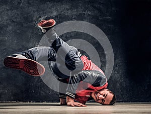 Hip-hop style dancer performs breakdance acrobatic elements.