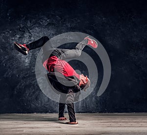 Hip-hop style dancer performs breakdance acrobatic elements.
