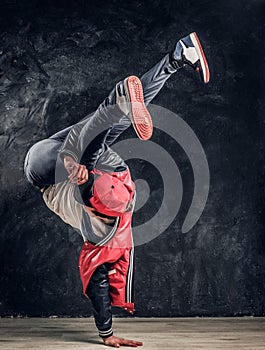 Hip-hop style dancer performs breakdance acrobatic elements.