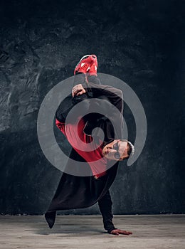 Hip-hop style dancer performs breakdance acrobatic elements.