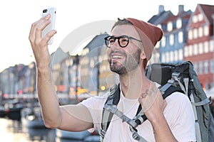 Hip male taking a selfie in Nyhavn, Copenhagen Denmark