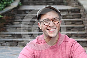 Hip man smiling wearing eyeglasses and hat