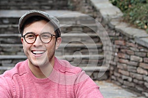 Hip man smiling wearing eyeglasses and hat