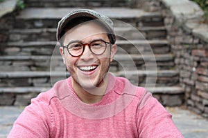 Hip man smiling wearing eyeglasses and hat