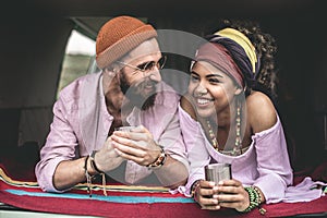 Hippie beloved couple drinking tea in retro van