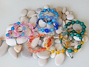 Hippie colorful bracelets on sea stones background