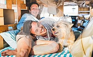Hippie couple with funny dog traveling together on vintage minivan transport - Life inspiration concept with indie people on mini photo