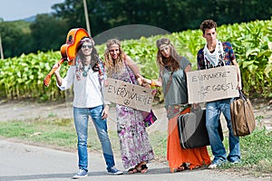 Hippie Group Hitchhiking on a Countryside Road