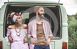 Hippie man and woman lean on retro van