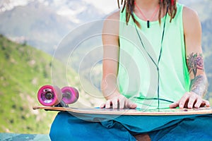 Hippie relaxing and handsome man listening to music with skateboard