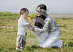 Hippie woman gives son a yellow flower
