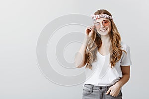 Hippies still among us. Portrait of attractive stylish young woman in trendy sunglasses and head bend, standing over