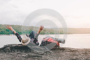 Hipster asian young girl with backpack enjoying sunset on peak mountain. Travel Lifestyle adventure concept