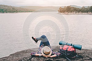 Hipster asian young girl with backpack enjoying sunset on peak mountain. Travel Lifestyle adventure concept