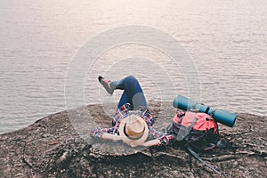 Hipster asian young girl with backpack enjoying sunset on peak mountain. Travel Lifestyle adventure concept