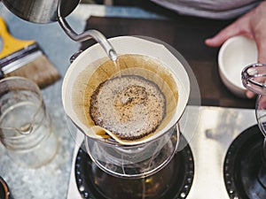 Hipster Barista making hand drip Coffee pouring water on filter photo