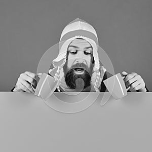 Hipster with beard and curious face having coffee