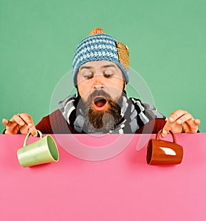 Hipster with beard and surprised face has coffee