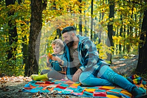 Hipster bearded dad with cute son spend time together in forest. Family time. Family leisure. Brutal bearded man and