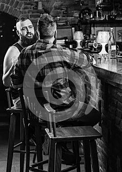 Hipster bearded man spend leisure with friend at bar counter. Strong alcohol drinks. Opening hours till last visitors