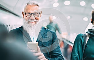 Hipster bearded man using mobile smart phone at shopping mall elevators - Trendy old person sharing content with smartphone