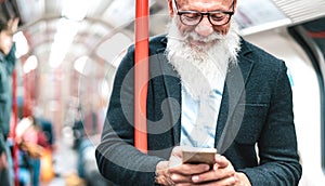 Hipster bearded man using mobile smart phone in subway train - Trendy adult person checking timetable with smartphone