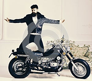 Hipster biker brutal in leather jacket on motorcycle enjoying richness. Superiority concept. Man, bearded biker in