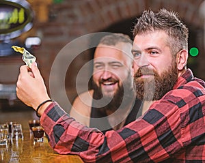 Hipster brutal bearded man spend leisure with friend at bar counter. Men relaxing at bar. Friendship and leisure. Friday