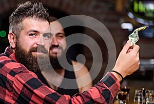 Hipster brutal bearded man spend leisure with friend at bar counter. Order drinks at bar counter. Men relaxing at bar