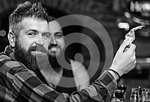 Hipster brutal bearded man spend leisure with friend at bar counter. Order drinks at bar counter. Men relaxing at bar