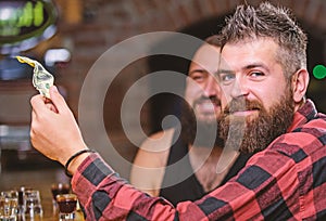 Hipster brutal bearded man spend leisure with friend at bar counter. Order drinks at bar counter. Men relaxing at bar