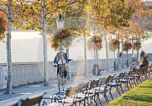 Hipster businessman commuter with bicycle traveling home from work in city.