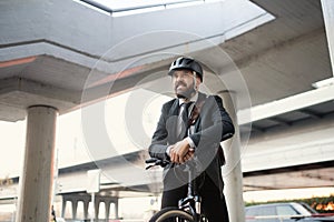 Hipster businessman commuter with electric bicycle traveling home from work in city.