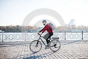 Hipster businessman commuter with electric bicycle traveling to work in city.