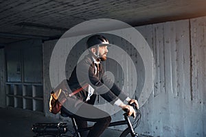 Hipster businessman commuter with electric bicycle traveling to work in city.