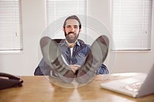 Hipster businessman relaxing at his desk