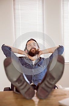 Hipster businessman relaxing at his desk